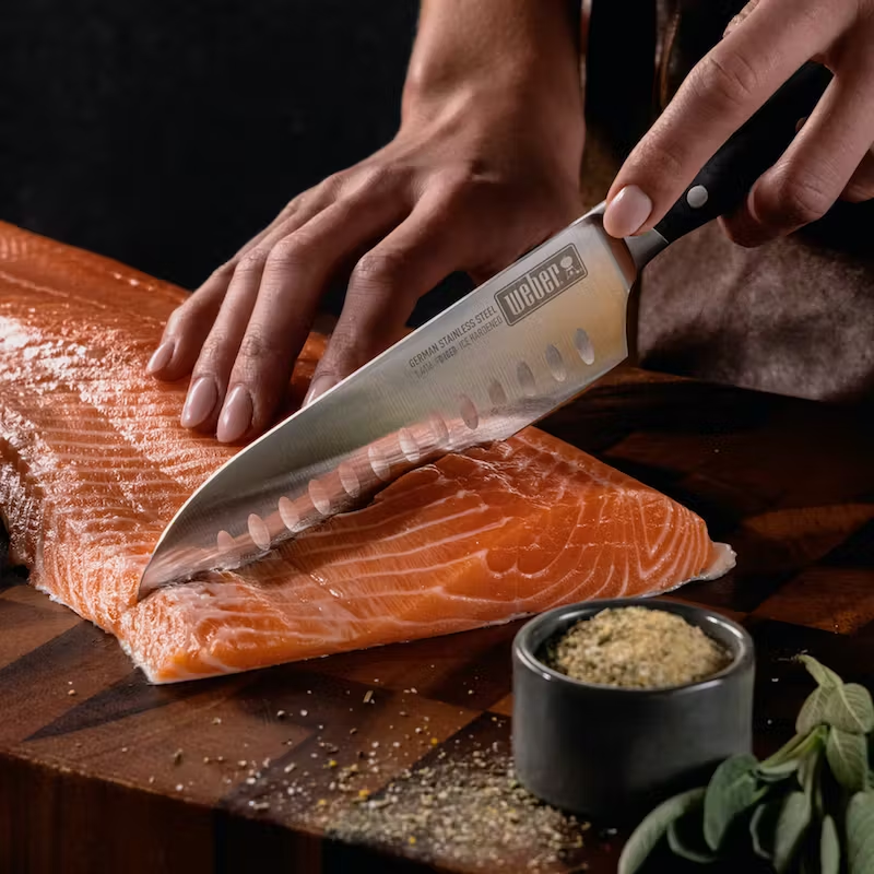 German steel cold forged Santoku knife cutting through salmon.